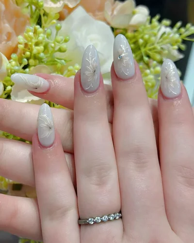 Milky white almond nails with fine painted flowers