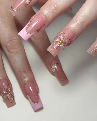 Long square pink nails with gold lines and 3D flowers